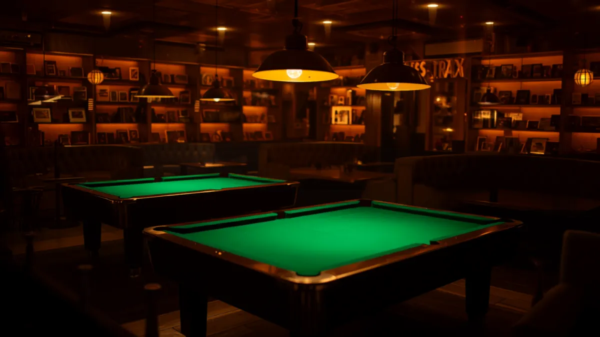 A modern game café with green billiard tables under warm hanging lights.